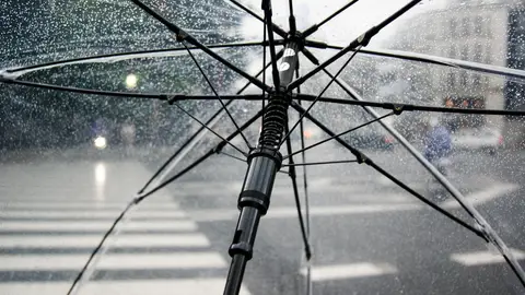 Una persona caminando bajo la lluvia con un paraguas Una nueva borrasca trae fuertes lluvias a España y deja en alerta a las Islas Canarias