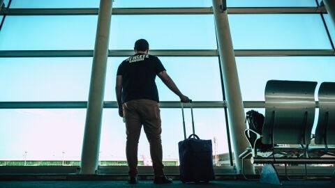 Un hombre espera en un aeropuerto