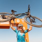 Ariadna Ródenas levanta su bicicleta tras ganar la edición 2022 de la Titan Desert de Arabia Saudí