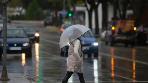 Una mujer se protege de la lluvia con el paraguas. La predicción de Jorge Rey: la fecha en la que empezarán la lluvias más abundantes