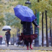 Varias personas se protegen de la lluvia con un paraguas en Madrid