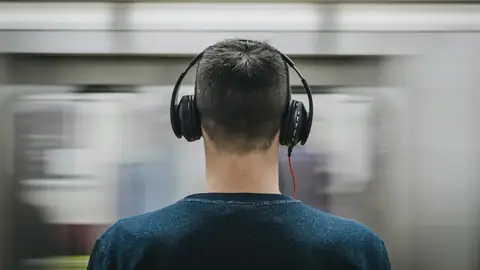 Un usuario de tren escuchando música. Un usuario de tren escuchando música.