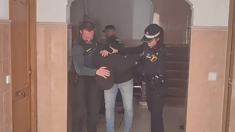 El joven detenido es sacado de la vivienda por los agentes sucesos