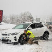 Un hombre poniendo cadenas en las ruedas por la nieve