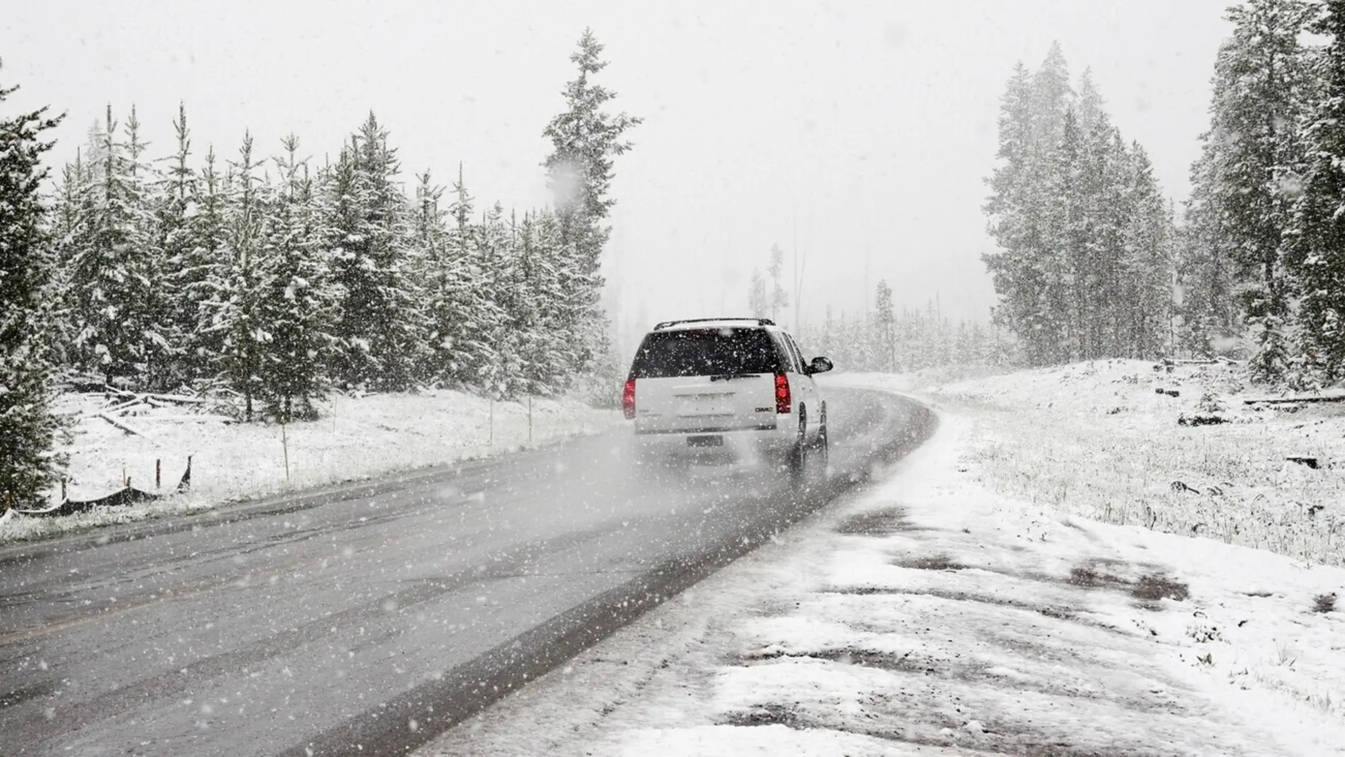 Un coche por una carretera con hielo y nieve