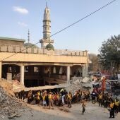 Trabajadores de los servicios de emergencia buscan posibles victimas entre los escombros de una mezquita de Peshawar tras un atentado suicida