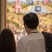 Dos personas contemplan en el Museo Nacional del Prado el cuadro cuadro ‘El jardín de las delicias’ del Bosco.