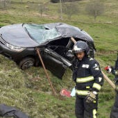Los bomberos trabajando junto al coche siniestrado