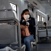 Una mujer usando mascarilla en el transporte público