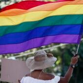 Vista de una bandera LGBTQ+ portada por una mujer, en una fotografía de archivo.