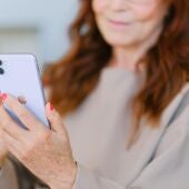 Imagen de archivo de una mujer sujetando un teléfono móvil