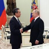 Vladimir Putin (d) estrecha la mano de Wang Yi durante su reunión en el Kremlin 