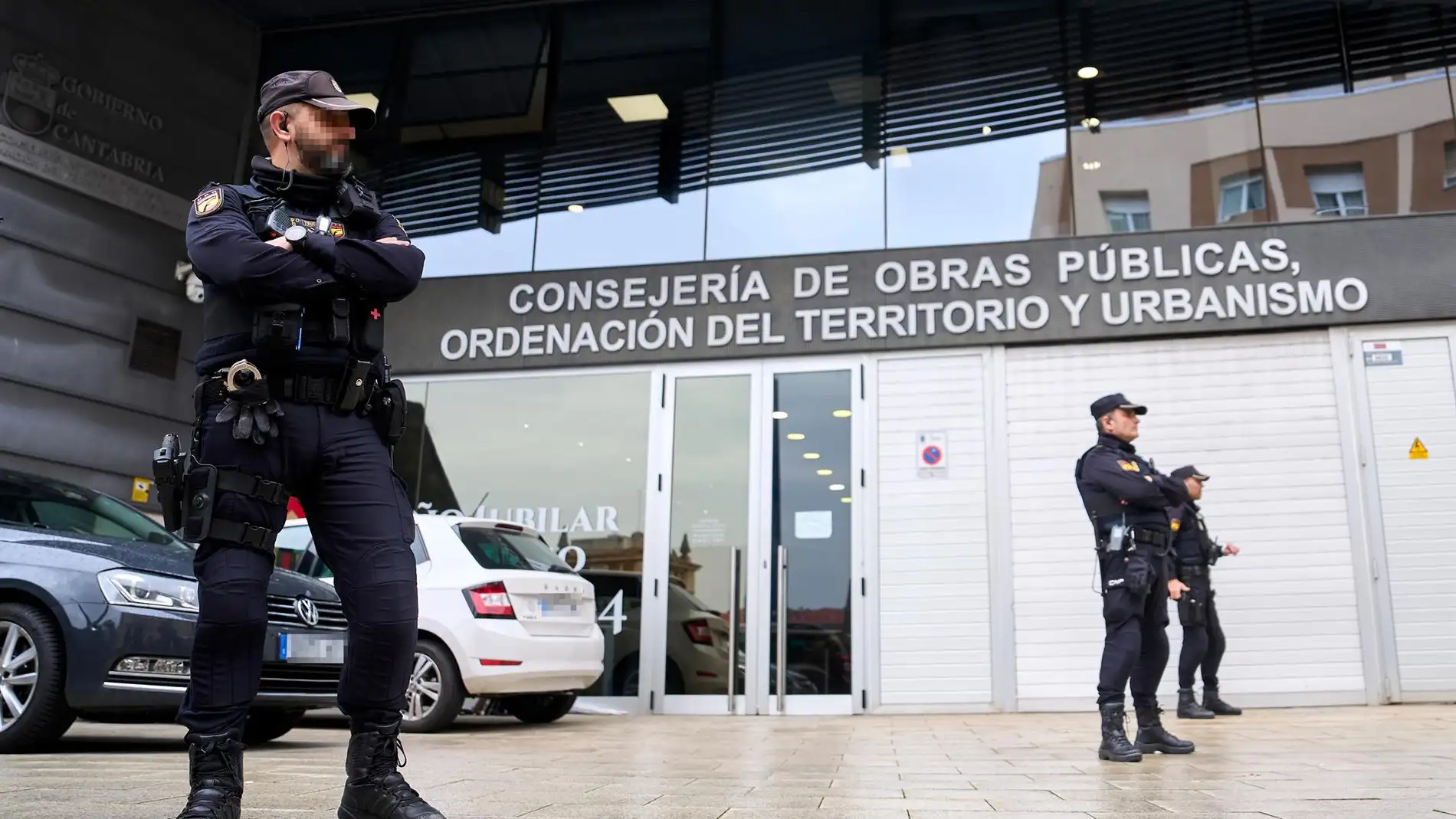 Varios policías en la entrada de la Consejería de Obras Públicas, Ordenación del Territorio y Urbanismo de Cantabria