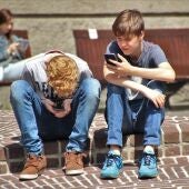 Imagen de archivo de dos adolescentes mirando el teléfono móvil