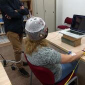 Una mujer con el dispositivo de la UMH de Elche para medir patrones cerebrales.