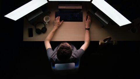 Una persona usa un ordenador con varias pantallas.