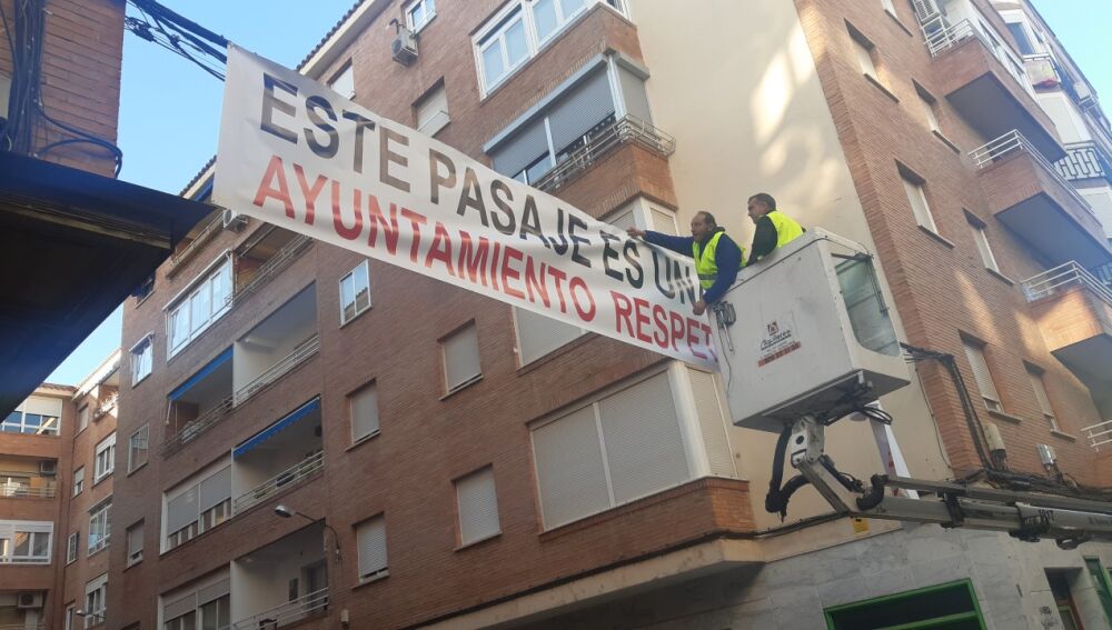 Instalación de la pancarta en el pasaje