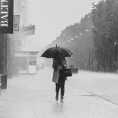 Imagen de archivo de una mujer paseando bajo la lluvia