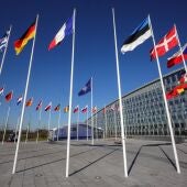 Un mástil vacío se alza entre las banderas de los miembros de la Alianza a la espera de la ceremonia de izamiento para la adhesión de Finlandia a la Organización fuera de la sede de la OTAN, en Bruselas (Bélgica).