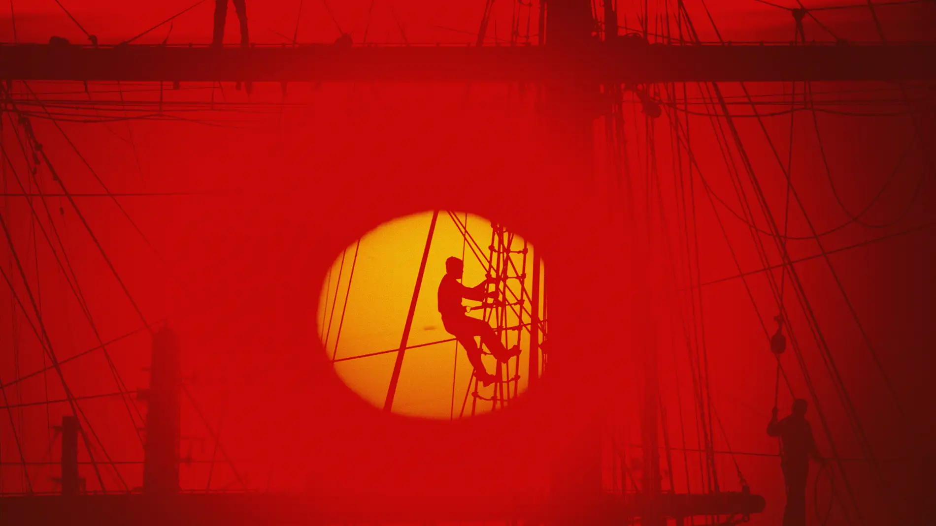Un marinero trepa por la jarcia de un barco al caer el sol. Buenos Aires, Argentina. 