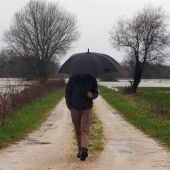 Imagen de un hombre caminando con un paraguas