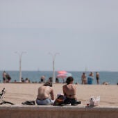 Varios jóvenes disfrutan del buen tiempo en la playa de la Malvarrosa en Valencia