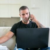 Imagen de archivo de un hombre hablando por teléfono mientras hace gestiones