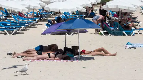 Imagen de archivo de varias personas tomando el sol en la playa Punta Prima de Menorca Imagen de archivo de varias personas tomando el sol en la playa Punta Prima de Menorca