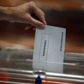 Una persona depositando su voto en la urna electoral