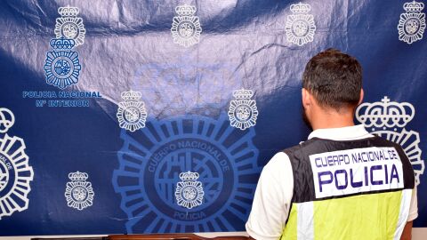 Agente de la Policía Nacional junto al arma y sustancia estupefaciente incautadas al detenido en Elche. 