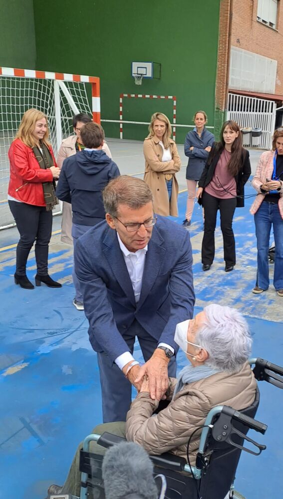 El presidente del PP, Alberto Núñez Feijóo, saluda a una votante en el colegio electoral