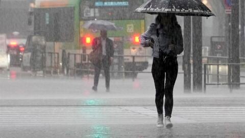 Imagen de archivo de una persona caminando bajo la lluvia 