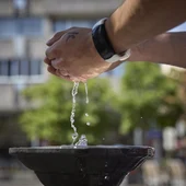 Una persona coge agua de una fuente Una persona coge agua de una fuente