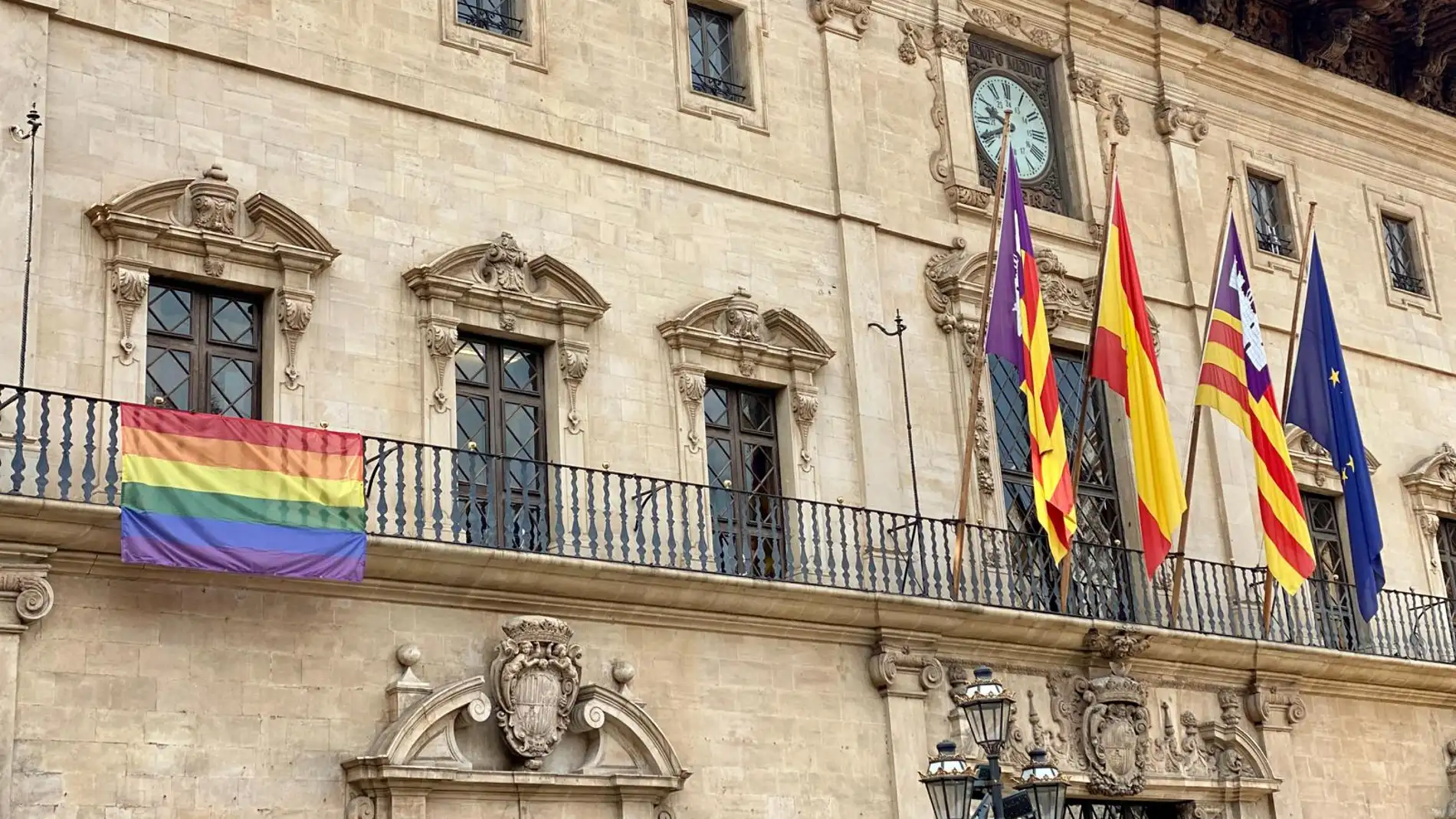 La bandera arcoíris cuelga de la fachada del Ayuntamiento de Palma con motivo del Día Internacional del Orgullo LGTBI