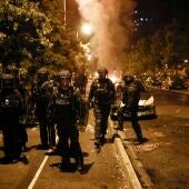 Policías antidisturbios junto a un vehículo incendiado en las protestas en Nanterre, Francia.
