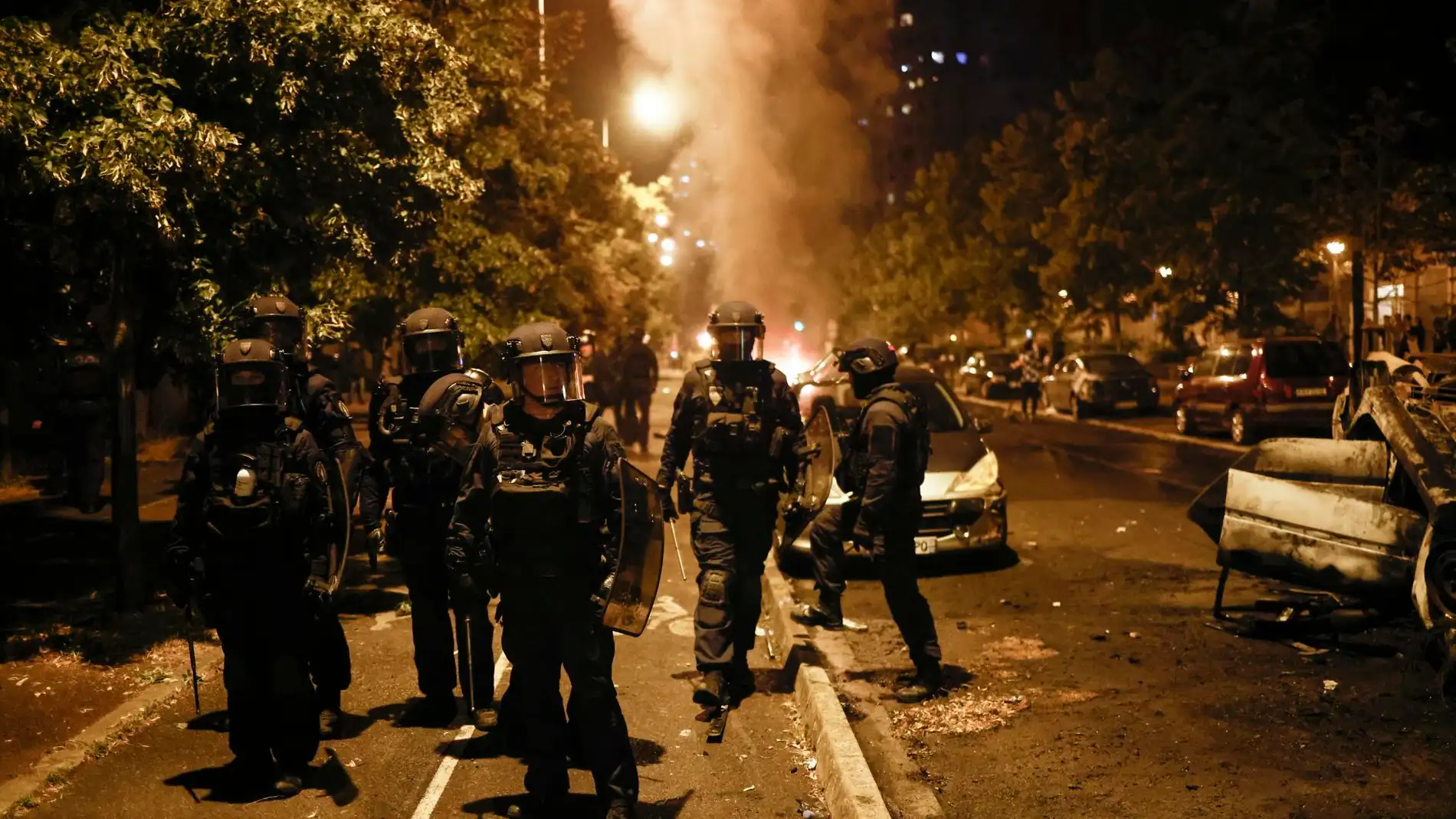 Policías antidisturbios junto a un vehículo incendiado en las protestas en Nanterre, Francia.