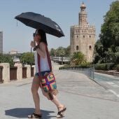 Una mujer se protege del sol con un paraguas en Sevilla