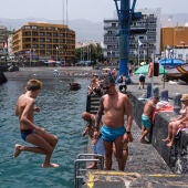 Un grupo de personas se refugia del calor bañándose en el muelle de Puerto de la Cruz (Tenerife)