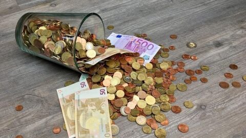 Un mont&oacute;n de monedas y billetes de euros, tirados por el suelo