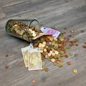 Un montón de monedas y billetes de euros, tirados por el suelo Un montón de monedas y billetes de euros, tirados por el suelo