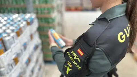 Una agente de la Guardia Civil con una de las bebidas decomisadas
