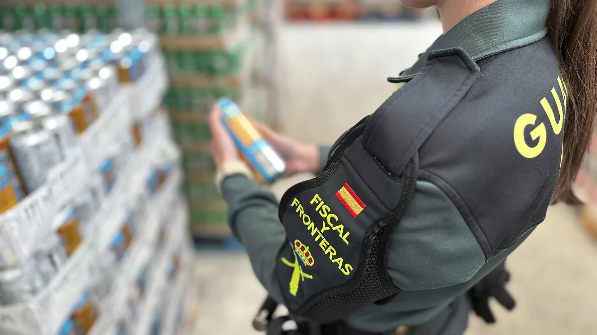 Una agente de la Guardia Civil con una de las bebidas decomisadas