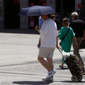 Un hombre se protege del sol con un paraguas en Madrid.