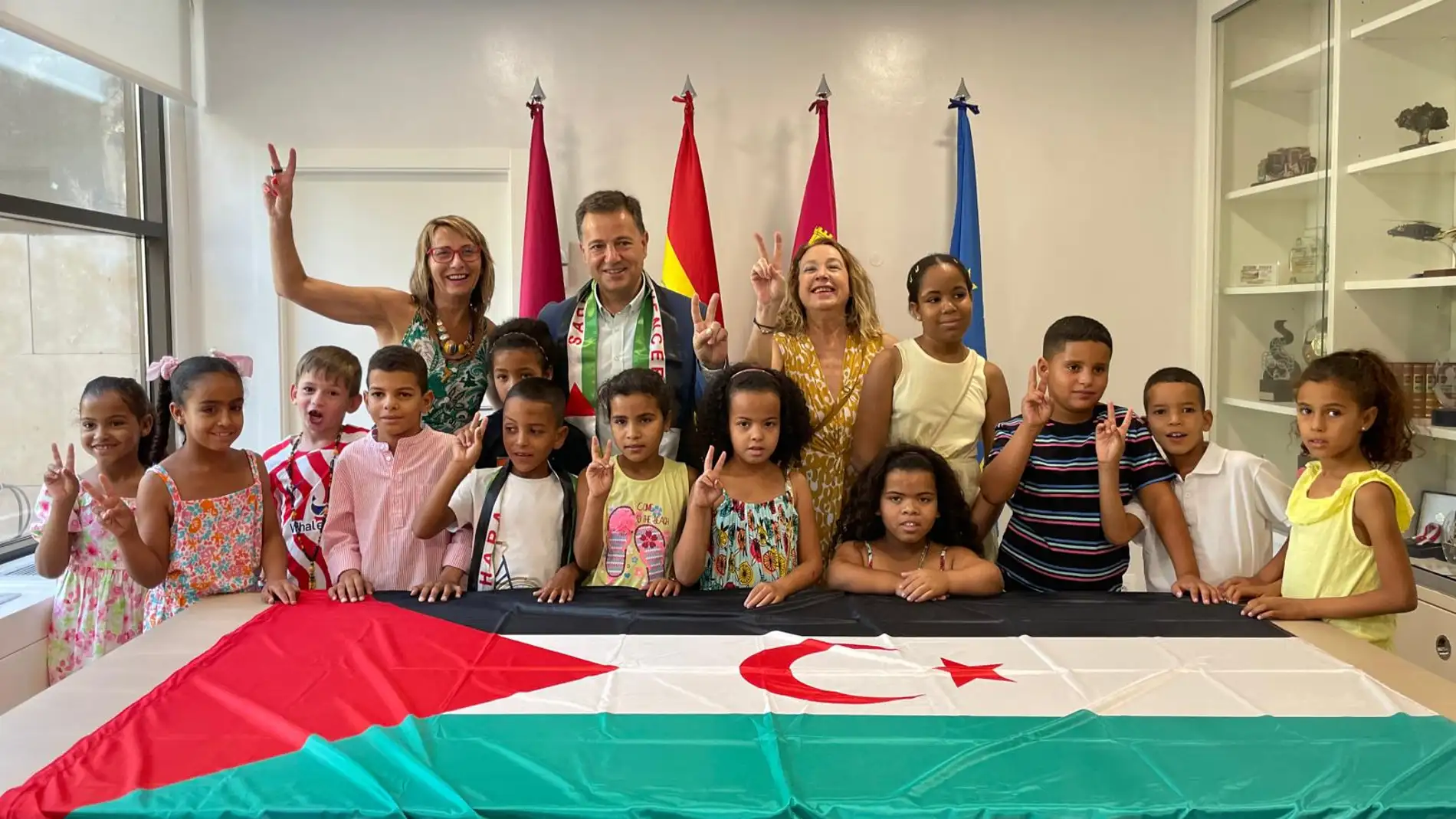El Alcalde. la coordinadora y la portavoz del programa posaban con los niños y niñas saharauis