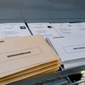 Papeletas, sobres, mesas y agua, dispuestos en un colegio electoral