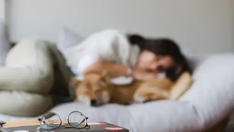 Imagen de archivo de una mujer durmiendo Imagen de archivo de una mujer durmiendo con su mascota