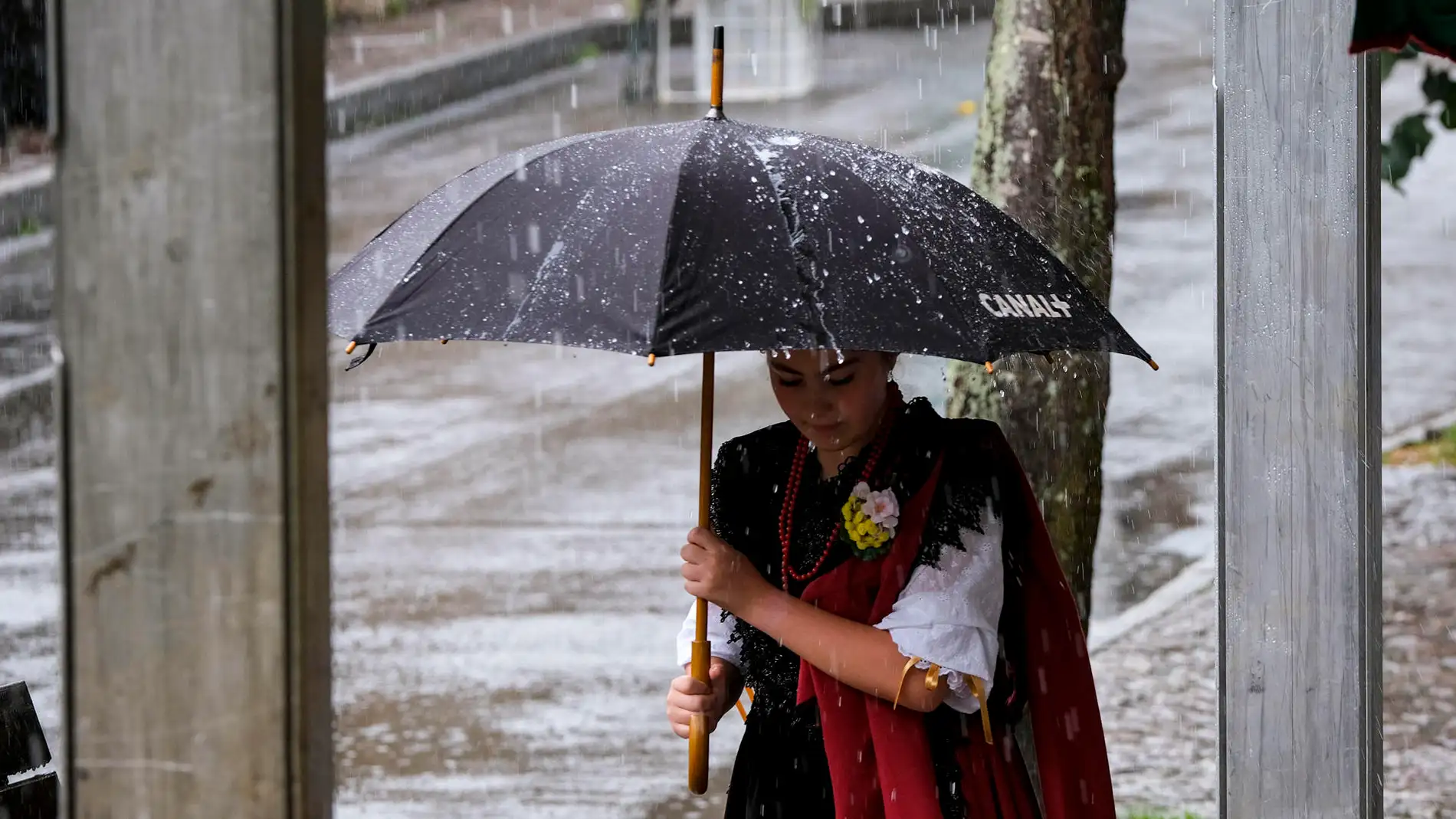 Una mujer se protege de la lluvia en Arenas de Cabrales, Asturias.