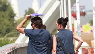 Un hombre cruza el puente de la Barqueta usando una carpeta para protegerse de las altas temperaturas, a 24 de agosto en Sevilla (Andalucía, España). La ola de calor acaba este jueves con la llegada de una vaguada que bajará las temperaturas. 