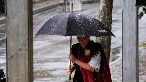 Una mujer se protege de la lluvia caída este domingo en Arenas de Cabrales, Asturias Una mujer se protege de la lluvia caída este domingo en Arenas de Cabrales, Asturias