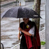 Una mujer se protege de la lluvia caída este domingo en Arenas de Cabrales, Asturias